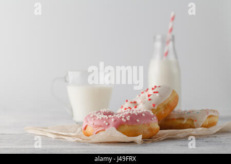 Donuts with glass of milk on wooden table Stock Photo