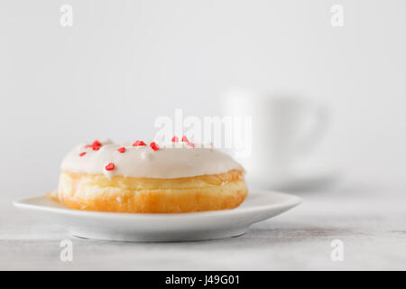 Single donut on white plate Stock Photo