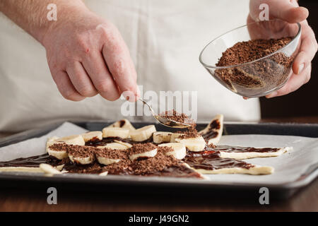 Chef pouring cake batter in a baking tin, close up Stock Photo