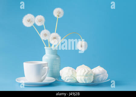 marshmallow candies of different colors in the glass on the blue background Stock Photo