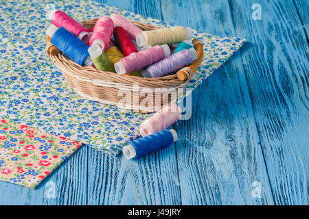 Multicolor sewing threads on wooden background Stock Photo