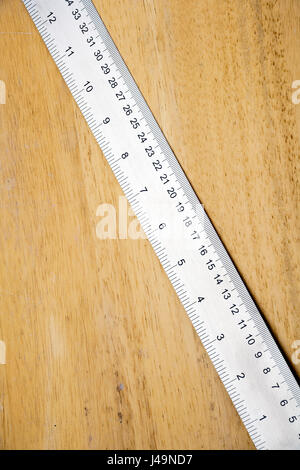 A shiny new steel rule on wood with copy space Stock Photo