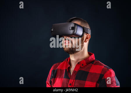 Young bearded man wearing virtual reality glasses Stock Photo