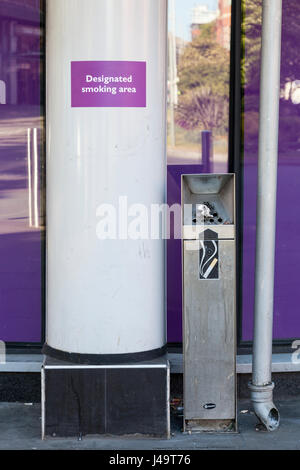 Designated Smoking Area sign next to a cigarette disposal bin or external ashtray, Nottingham, England, UK Stock Photo