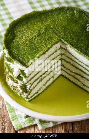Snack spinach pancakes cake with cheese cream close-up on the table. Vertical Stock Photo