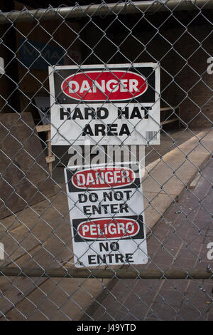 Danger Hard Hat Area sign attached to fence. Stock Photo