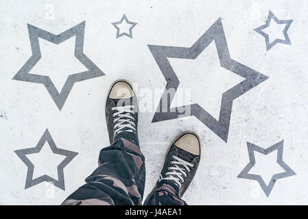Sneakers on the road with star shape imprint - talent, vip, prize and award concept Stock Photo