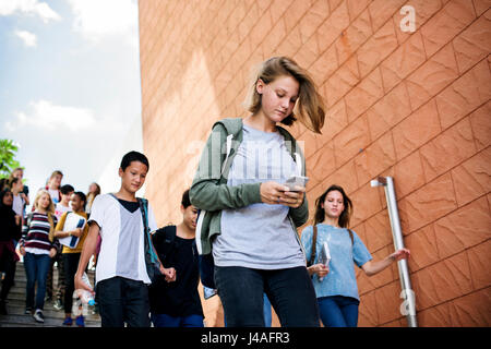 Group of school friends walking down staircase Stock Photo