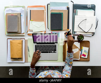 African American Woman Sitting Getting Pen on White Table Office Stock Photo