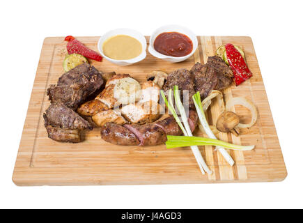 Mixed grilled meats platter with vegetables and sauces. Isolated on a white background. Stock Photo