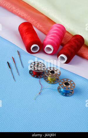 Various accessories for sewing on a sewing machine on a cloth background Stock Photo