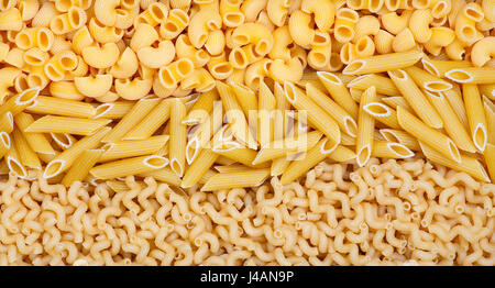 Three different kinds of pasta are separated by a curving line Stock Photo