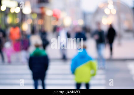 picture with motion blur of a crowd of people crossing a city street at ...