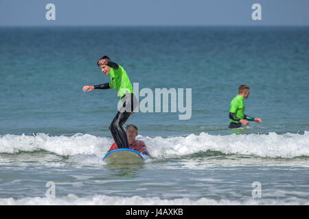 A surf school novice surfs for the first time Fistral Beach Newquay Cornwall Surfing Surfer Learner Learning Seaside Sea Tourism Stock Photo