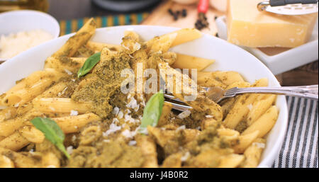 Close up view of Italian pasta (penne) with pesto sauce Stock Photo