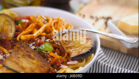 Close up view of  Italian pasta (spaghetti, linguine) with tomato sauce and aubergine Stock Photo