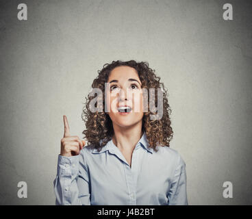 Headshot attractive business woman having good idea aha thought pointing index finger up solution found isolated on grey wall background. human face e Stock Photo