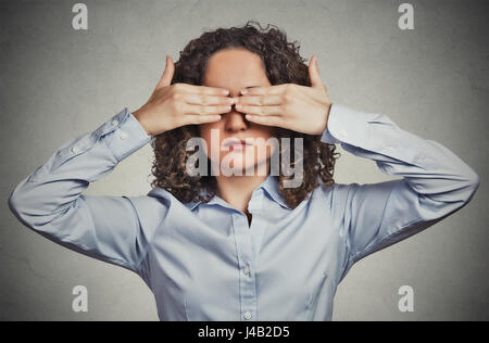 Closeup portrait headshot young woman closing covering eyes with hands can't look hiding avoiding situation isolated grey wall background. See no evil Stock Photo