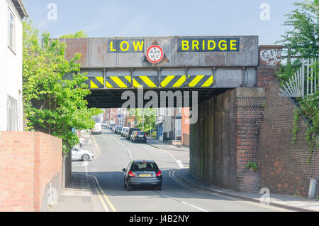 Railway bridge with 'low bridge' crosses a road at Cradley Heath in the Black Country, West Midlands Stock Photo
