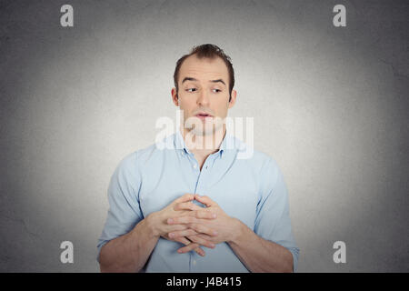 Closeup portrait jealous envious, guilty, sly young business man, student employee funny guy sneakily looking aside, assessing situation isolated grey Stock Photo