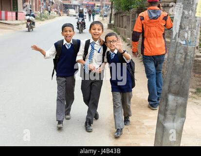 Smiling Nepalese schoolboys in uniforms walking on the street, Bhaktapur. Stock Photo