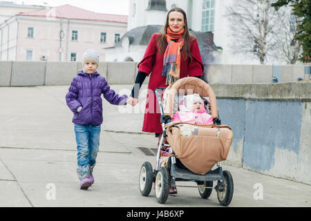 Happy mother walks with two daughters Stock Photo