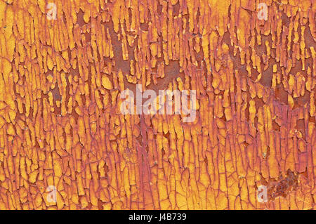 cracked and flaky yellow paint on a rusty metal background Stock Photo