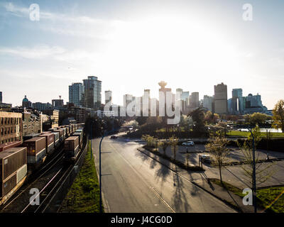 Vancouver skyline and cargo trains on railroad with sky background during sunset Stock Photo