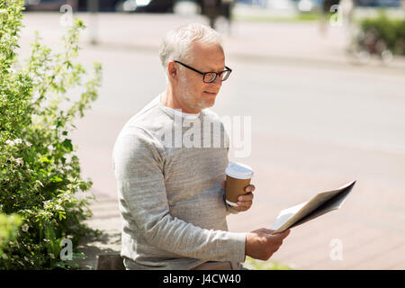 senior man reading newspaper and drinking coffee Stock Photo