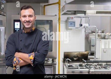 young caucasian chef into kitchen smiling at camera Stock Photo