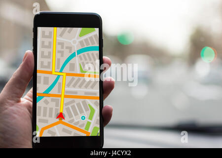 GPS Navigation on Mobile Phone Device and Transportation Concept. Male Hand Using Navigation System Map Tracking on Smartphone with Copy Space. Stock Photo