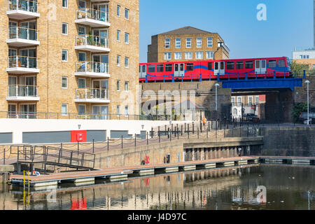 London, UK - April 08, 2017 - Waterside apartments at Limehouse Basin Marina  with Docklands Light Railway passing in the background Stock Photo