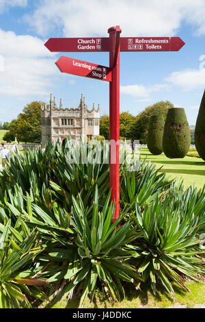 Multi armed signpost in the formal garden / Gardens at Lanhydrock, Bodmin, Cornwall. The Gatehouse is in the distance. Stock Photo