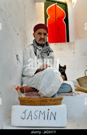 SIDI BOU SAID, TUNISIA OCT 6, 2009:  Jasmine seller in doorway, Sidi Bou Said, Tunisia, North Africa, Africa Stock Photo