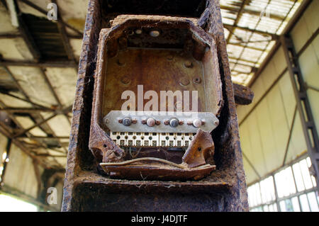 Old brown rusty switches in control box, ruins of factory Stock Photo
