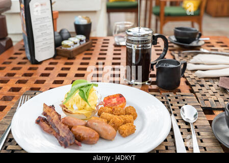 Delicious breakfast with eggs Benedict, bacon, sausage, and potato hash brown Stock Photo