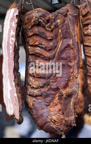 Homemade and smoked bacon hanging in a street market, selective focus and small depth of field Stock Photo