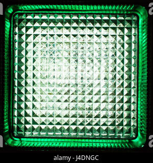 Square green glass block. Transparent building material. Element of the glass wall. Texture or background. Stock Photo