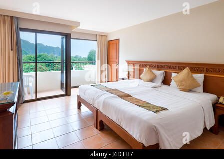 Bed in the hotel and view of the beautiful mountains from the window Stock Photo