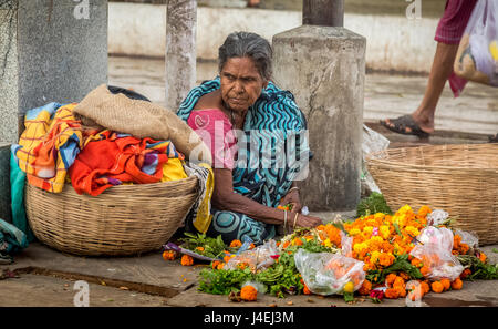 An Indian aged woman sells flowers at Mallick ghat near Howrah bridge at Kolkata, India. Stock Photo