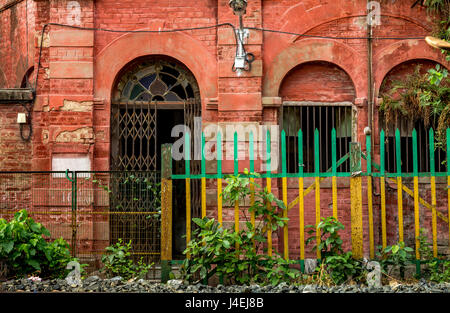 Vintage red brick house exterior with railings and blank name plate having an old worn out look for background content. Stock Photo