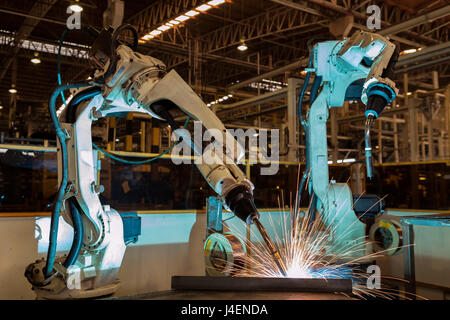 Team robots are welding in car factory Stock Photo