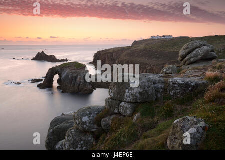 A colourful sunset overlooking the islands of Enys Dodnan and the Armed Knight at Lands End, Cornwall, England, United Kingdom