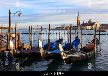 Gondolas, San Marco waterfront at sunset in winter, view to San Giorgio Maggiore, Venice, UNESCO, Veneto, Italy Stock Photo