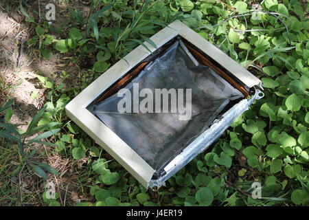 Composition of a broken computer on the grass. Stock Photo