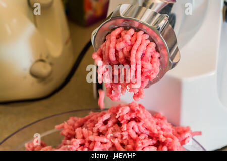 Closeup of minced raw meat coming out from grinder Stock Photo