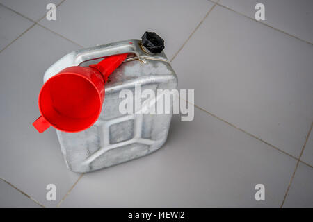 Petrol metal can with red fueling funnel Stock Photo