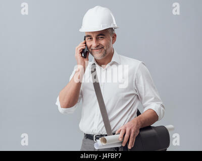 Construction engineer using a smartphone, he is having a phone call Stock Photo