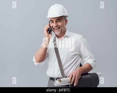 Construction engineer using a smartphone, he is having a phone call Stock Photo