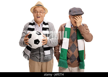 Two elderly football fans with one of them cheering and the other holding his head in disbelief isolated on white background Stock Photo